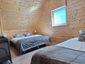 a bedroom with two beds in a log cabin at Morskie Sarbinowo in Sarbinowo