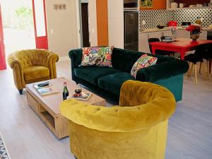 a living room with a green couch and a table at Romantic Boutique Cottage in upper Hogsback in Hogsback