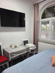 a room with a table and chairs with a tv on the wall at Room Nena in Senj