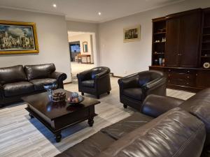 a living room with leather furniture and a coffee table at Crocus Corner - Kyalami in Kyalami