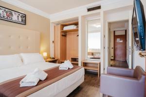 a hotel room with a bed and a chair at Nyala Suite Hotel in Sanremo