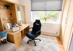 a chair in a room with a desk and a window at Bliss Home in Harrow on the Hill