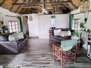a living room with couches and a table at Anchors Aweigh in Hibberdene