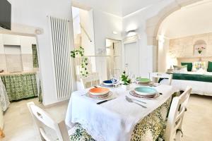 a dining room with a table and chairs and a bed at Il Rifugio Dei Nonni in Ostuni