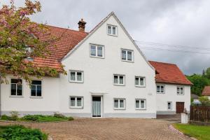 a white house with a red roof at Ferienwohnung Trendelmühle Lautrach in Lautrach