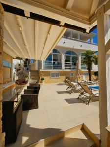 an outdoor patio with chairs and a pool at Apartments Sun Dance 2 with heated Pool in Novalja