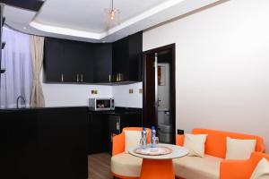 a living room with orange chairs and a table at Bustani Tulivu in Bungoma