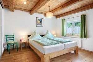 a bedroom with a bed and a chair and a window at Ferienwohnung Trendelmühle Lautrach in Lautrach
