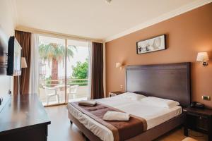 a hotel room with a bed and a balcony at Nyala Suite Hotel in Sanremo
