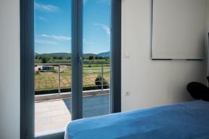 a bedroom with a window with a view of a field at Gaia Villa in Thesprotikón