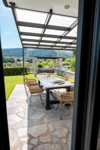 a patio with a table and chairs and a view at Gaia Villa in Thesprotikón