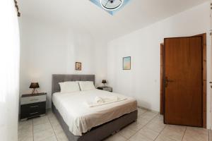 a bedroom with a bed and a clock on the wall at Zante's Northern View in Koríthion