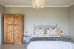 a bedroom with a bed and a chandelier at Begha 180 Beach House in Begha Mouth