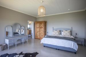 a bedroom with a bed and two dressers and mirrors at Begha 180 Beach House in Begha Mouth