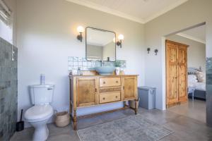 a bathroom with a sink and a toilet and a mirror at Begha 180 Beach House in Begha Mouth +22 photos