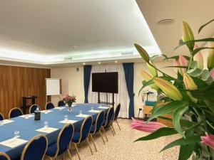 a long table in a room with chairs and a screen at Hotel Piroga Padova in Selvazzano Dentro