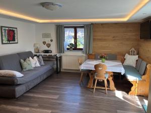 a living room with a couch and a table at Blumenwohnung Irene DORN in Andechs