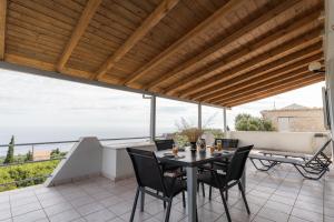 a patio with a table and chairs on a balcony at Zante's Northern View in Koríthion