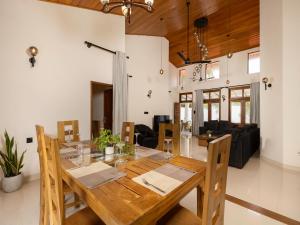 a dining room and living room with a wooden table at The Calm boutique Villa in Ahangama