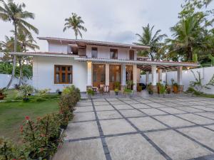 a house with a courtyard in front of it at The Calm boutique Villa in Ahangama