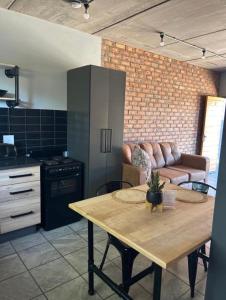 a kitchen and living room with a table and a couch at Red Robin Guesthouse in Postmasburg +1 photo