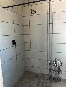 a shower with a glass door in a bathroom at Red Robin Guesthouse in Postmasburg