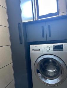 a washing machine in a room with a window at Red Robin Guesthouse in Postmasburg