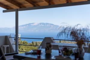 a view of the ocean from a restaurant with a table at Zante's Northern View in Koríthion