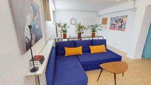 a living room with a blue couch and yellow pillows at Fewo Loft Konstanz in Konstanz
