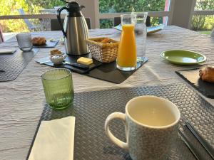 a table with a cup of orange juice and a glass at La Chambre de Kerly in Pléguien