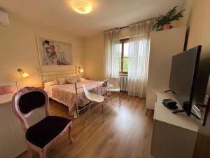 a bedroom with a bed and a table and a tv at The little lake Verona villa in Bovo