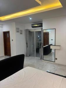 a living room with a bed and a mirror at Immeuble cgk in Cocody