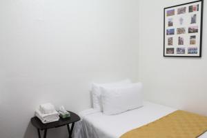a white bed with a white comforter next to a white wall at Union Hotel in San Francisco
