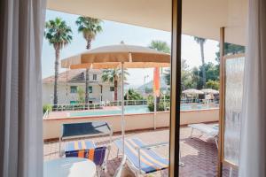a balcony with a table and chairs and a pool at Nyala Suite Hotel in Sanremo