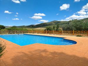 a swimming pool in a yard with a wooden fence at Cortijo El Búho - Casa rural con piscina privada en Montefrío in Montefrío