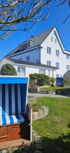 a blue and white bench in front of a house at Strandhotel Sylt Wenningstedt in Wenningstedt