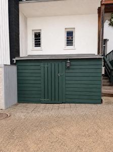 a green garage door on a white house at Hotel Pemü in Arnsberg