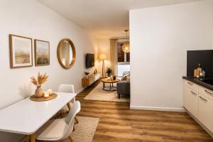 a kitchen and living room with a white table and chairs at StayIN Suites in Griesheim