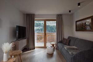 a living room with a couch and a large window at Residence Stella Alpina in Santa Cristina Gherdëina