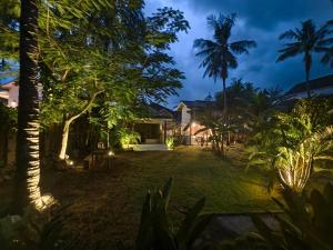 a view of the yard of a house at night at Kayu Cottage in Gili Trawangan