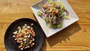 two plates of food with a salad on a table at SENJA Dewata in Mitoyo
