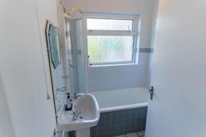 a bathroom with a tub and a sink and a window at Sneem Townhouse in Sneem +16 photos