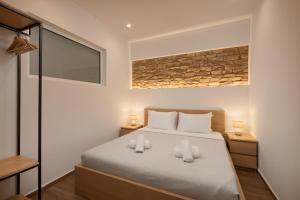a bedroom with a bed with two white towels at Kitron Blue Seaside Luxury Apartment in Agios Nikolaos