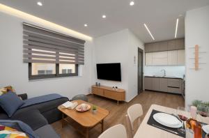 a living room with a couch and a table at Kitron Blue Seaside Luxury Apartment in Agios Nikolaos +13 photos
