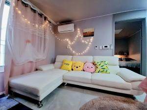 a living room with a white couch with pillows on it at 20프로할인 대전역 단독주택 우송대 복층형하우스 숮불바베큐하우스 in Daejeon