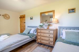 a bedroom with two beds and a dresser with a mirror at 3 Bed in Bassaleg oc-bow138 in Bassaleg