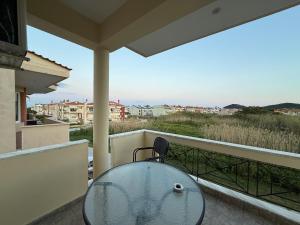 a glass table on a balcony with a view at Apartment Deniz in Nea Peramos