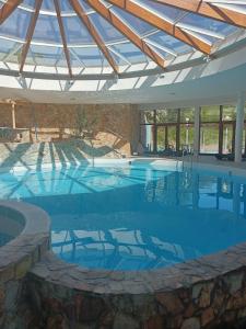 a large swimming pool with a roof at Hotel FLÓRA retro in Dudince