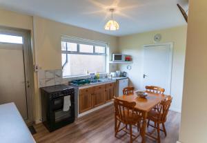 a kitchen with a wooden table and a table and a dining room at Sneem Townhouse in Sneem