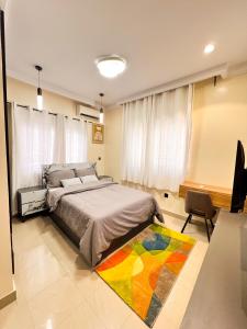 a bedroom with a bed and a colorful rug at Casa Midelle in Alagbado